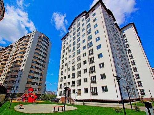 un grande edificio bianco accanto a due edifici alti di Cozy apartment a Chişinău