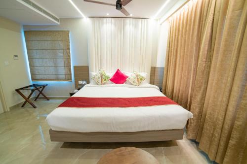 a bedroom with a large bed with red pillows at The Beacon Hotel Visakhapatnam in Visakhapatnam