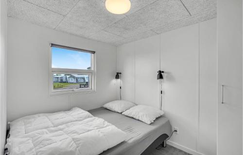 ein weißes Schlafzimmer mit einem Bett und einem Fenster in der Unterkunft Amazing Home In Assens With House Sea View in Assens