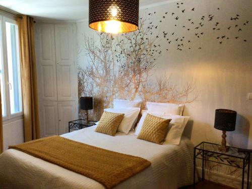 1 dormitorio con 1 cama con pájaros en la pared en Chez Janine, en Saint-Laurent-dʼAigouze