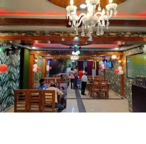 a restaurant with people sitting in chairs in a room at Hotel Vinayak Vihar, Sasaram in Ara