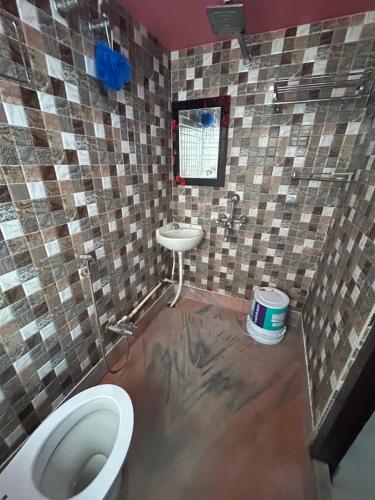 a bathroom with a toilet and a sink at ROOP AMRIT GUEST HOUSE in Agartala