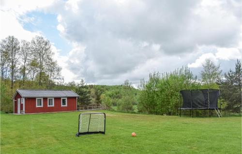 a field with a red house and a goal at Awesome Home In Askome With Wifi in Askome