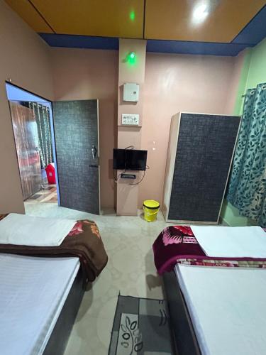 a room with two beds and a tv in it at ROOP AMRIT GUEST HOUSE in Agartala