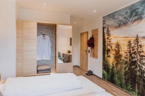 um quarto com uma cama branca e uma camisa pendurada numa parede em Pascals Ruhestube em Mörsdorf