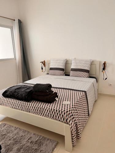 a bedroom with a bed with a black and white comforter at Super appartement central avec patio. in Santa Maria