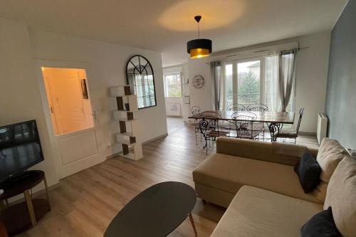 un salon avec un canapé et une table dans l'établissement Le Pegan - Appartement 2 chambres proche du centre de Ferney et de Palexpo, à Ferney-Voltaire