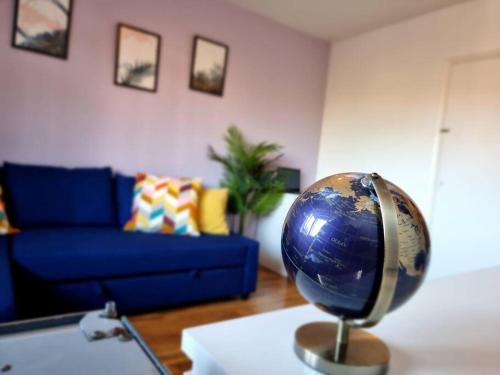 a living room with a blue couch and a globe on a table at Lovely House with garden in London