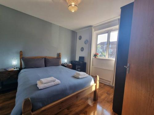 a bedroom with a bed with two towels on it at Lovely House with garden in London