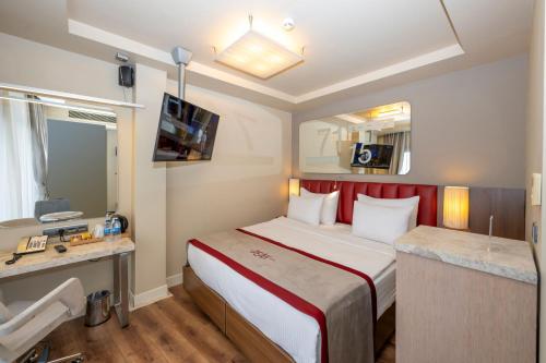 a hotel room with a large bed and a desk at Ramada By Wyndham Istanbul Pera Taksim in Istanbul