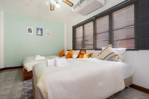 Un dormitorio con dos camas blancas grandes y una ventana. en Solene Home Patong, en Patong Beach