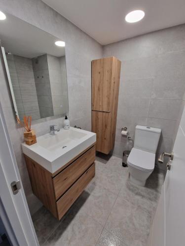 カンブリルスにあるApartamento Sol de Españaのバスルーム(洗面台、トイレ、鏡付)