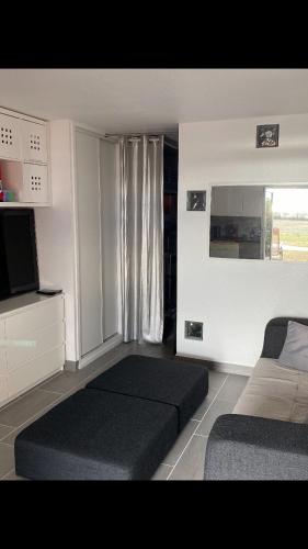 - un salon avec 2 lits et une télévision dans l'établissement Grand studio bord de mer plus piscine, à Sète