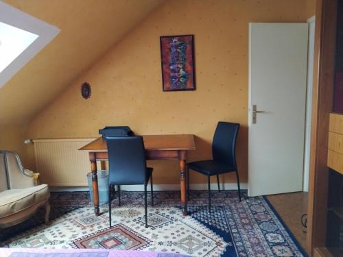 une salle à manger avec une table et deux chaises dans l'établissement Étage indépendant. 2 chambres + cuisine, à Pontivy