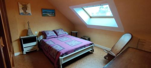 une chambre avec un lit et une lucarne dans l'établissement Étage indépendant. 2 chambres + cuisine, à Pontivy