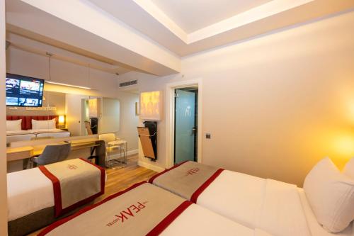 a hotel room with two beds and a desk at Ramada By Wyndham Istanbul Pera Taksim in Istanbul