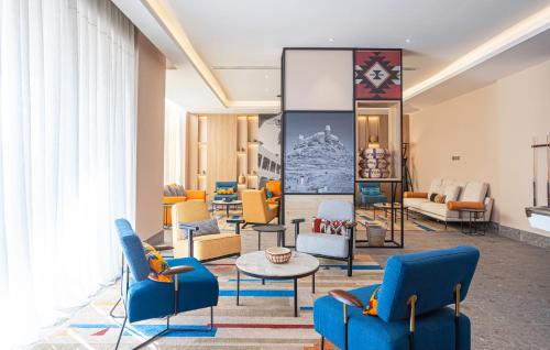 a lobby with chairs and tables and a mirror at Ewaa Express Hotel - Al Jouf in Sakakah