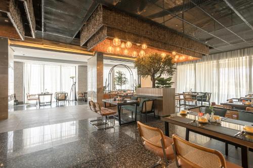 a restaurant with tables and chairs in a room at Ewaa Express Hotel - Al Jouf in Sakakah