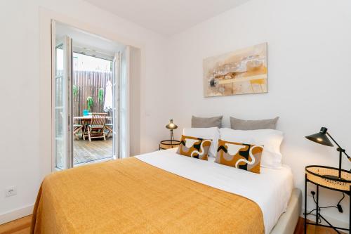 a bedroom with a large bed and a balcony at Gonzalos's Guest Apartments - Alfama Terrace in Lisbon