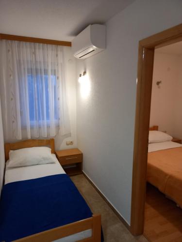 una piccola stanza con due letti e uno specchio di Žulj Vodice a Vodice