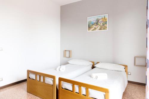 two twin beds in a room with white walls at La Ginestra - between lake and mountains in Colazza