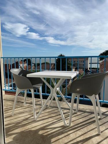d'une table blanche et de deux chaises sur un balcon. dans l'établissement Studio face mer Accès direct à la plage, à La Bernerie-en-Retz