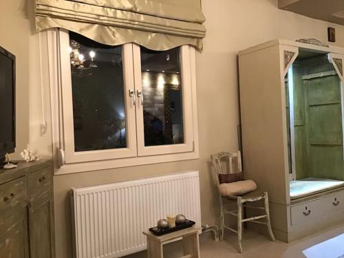 a room with a window and a chair and a table at Corner House Volos in Volos