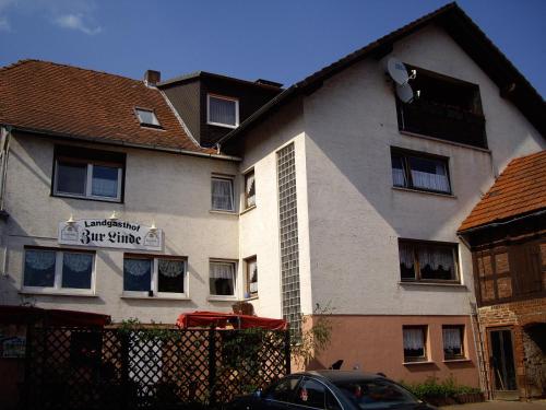- un grand bâtiment blanc avec un panneau dans l'établissement Landgasthof Zur Linde, à Münchhausen
