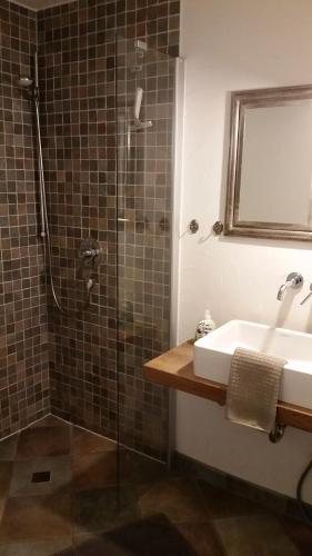 une salle de bain avec une douche avec un lavabo et une douche dans l'établissement Südstrandperle, à Wyk auf Föhr