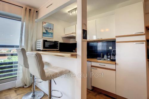 a kitchen with a counter and a chair in it at Saint-Cyprien plage, charmant studio meublé vue mer in Saint-Cyprien