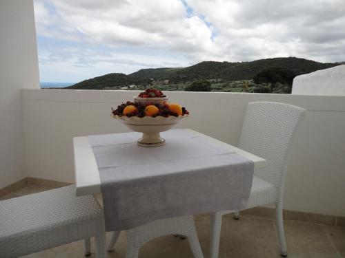 a bowl of fruit sitting on a table with two chairs at Masseria Santa Teresa in Monopoli