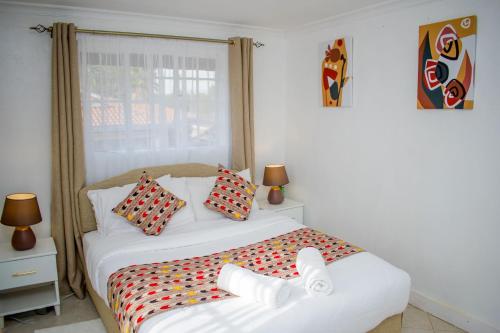 um quarto com uma cama grande e almofadas coloridas em 16 Arabella Residence near Waterfront Mall - Karen em Karen