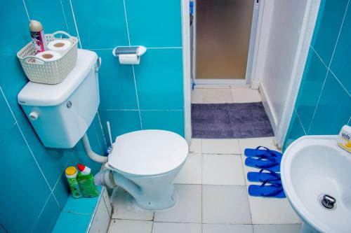uma casa de banho azul com um WC e um lavatório em 16 Arabella Residence near Waterfront Mall - Karen em Karen