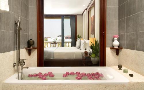 y baño con bañera con flores rosas. en The Elephant, en Siem Reap