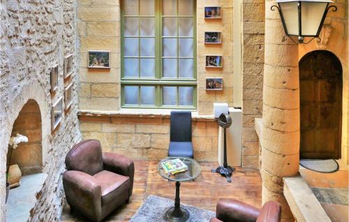a room with a chair and a table and a building at La Labrousse in Sarlat-la-Canéda
