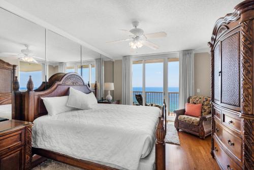 a bedroom with a bed and a balcony with the ocean at Majestic Beach Towers 1-1701 in Panama City Beach