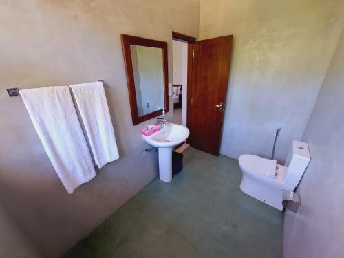 a bathroom with a sink and a toilet and a mirror at Atrium Hiriketiya in Hiriketiya