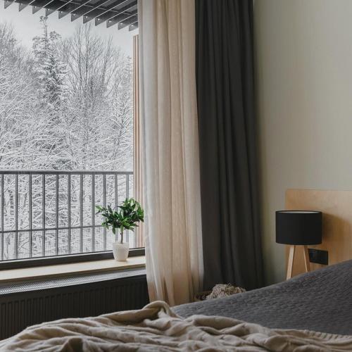 1 dormitorio con cama y ventana con vistas en Easy Stay - Apartment Kokhta Mitarbi, en Bakuriani
