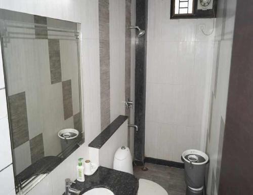 a bathroom with a sink and a mirror and a toilet at Gurudev Palace, Banda "Couples NOT Allowed" in Bānda