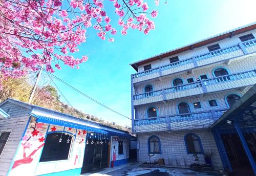 ein Gebäude mit rosa Blumen davor in der Unterkunft 儷福花園山莊Lifu Garden Inn in Hualing