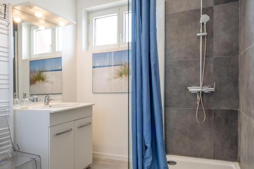een badkamer met een douche en een wastafel bij Maison confortable, terrasse et jardin à Amiens in Amiens