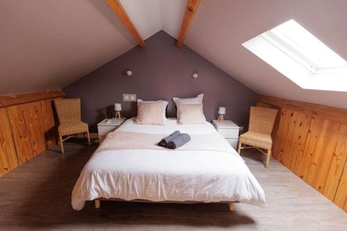 a bedroom with a large bed with two chairs at L'appart Cosy -Proche Disney in Mareuil-lès-Meaux