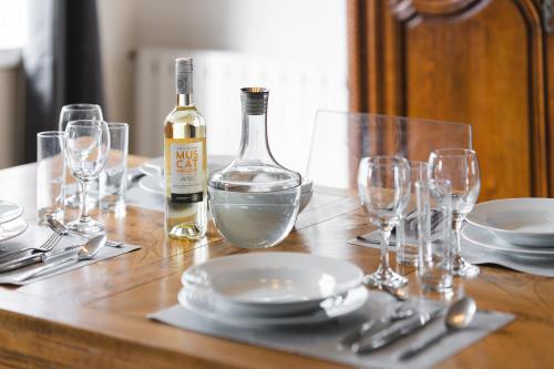 a table with a bottle of wine and glasses on it at Maison confortable, terrasse et jardin à Amiens in Amiens
