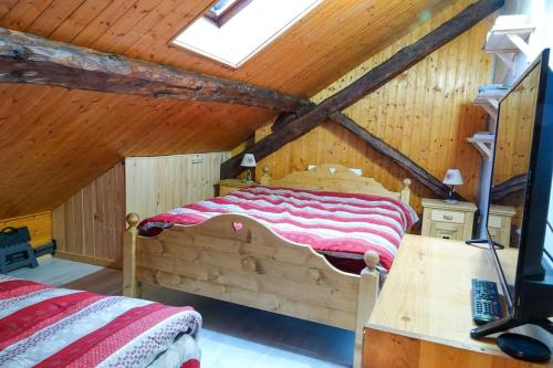 um quarto com uma grande cama de madeira num sótão em Les 3 marmottes duplex proche de la station Les Karellis em Montricher-Albanne