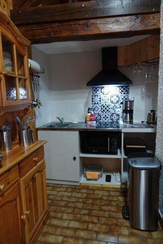 une cuisine avec un évier et une cuisinière four supérieur dans l'établissement Les 3 marmottes duplex proche de la station Les Karellis, à Montricher-Albanne