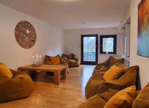 ハノーファーシュ・ミュンデンにあるGästehaus am Weser-Radwegのリビングルーム(ソファ、テーブル、キャンドル付)