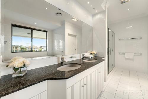 łazienka z 2 umywalkami i dużym lustrem w obiekcie stunning prestige residence w mieście Gold Coast