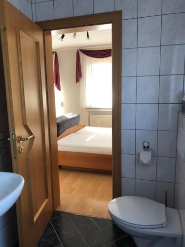 a bathroom with a toilet and a bedroom with a bed at Weingut Lehnert-Später in Piesport