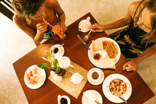 two women sitting at a table with food on it at Atrium Hiriketiya in Hiriketiya