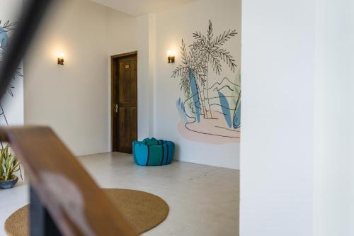 a hallway with a chair and a painting on the wall at Atrium Hiriketiya in Hiriketiya